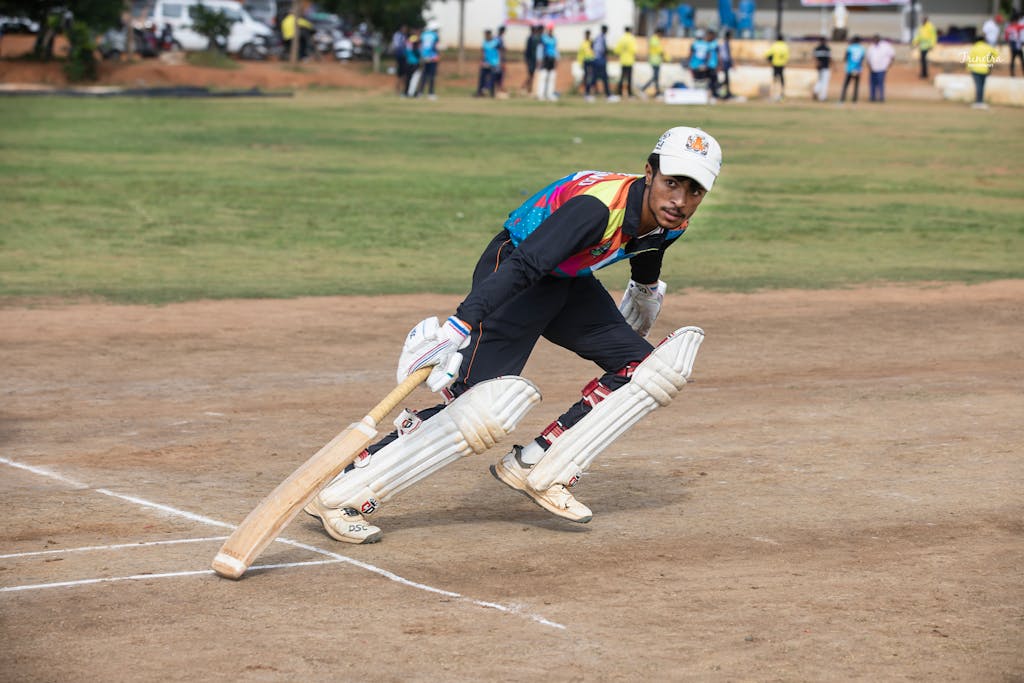 today match prediction colorful attire bats during a daytime match on a sunny field.