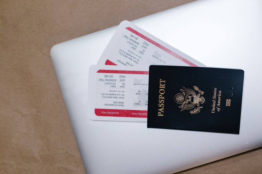 IPL 2026 Ticket Booking Online of a passport and boarding passes on a laptop, symbolizing travel preparation.
