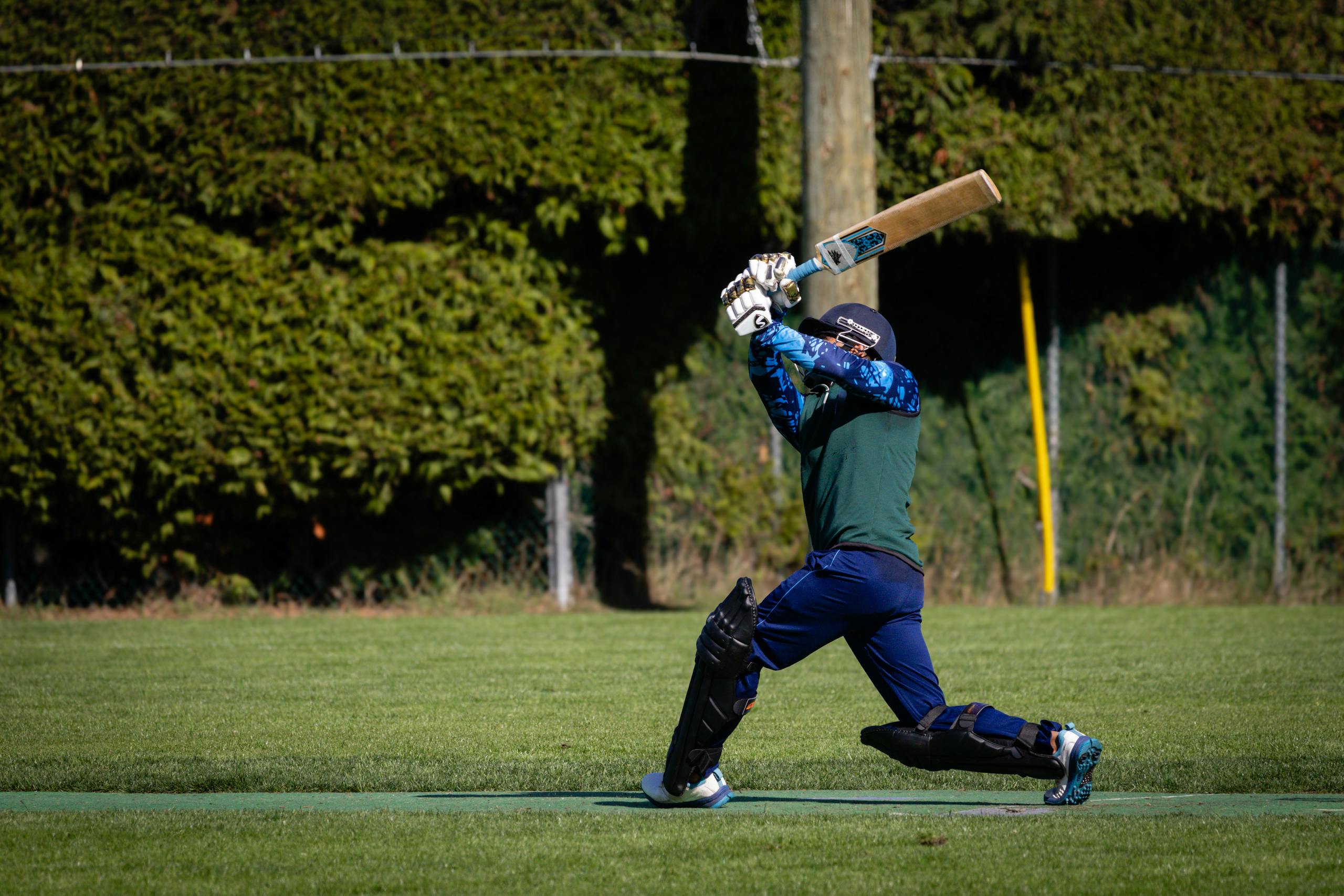 Playing 11 today powerful shot during a cricket match on a sunny day.