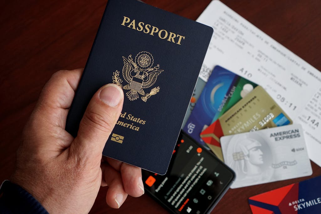 
Ticket Booking Online A close-up of a US passport with credit cards, tickets, and a mobile phone on a table.