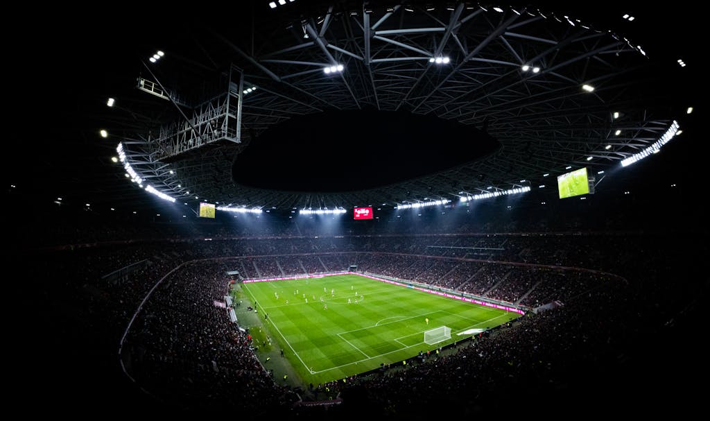 Full Match List Aerial view of a night football match in Budapest. Illuminated stadium full of fans adds dramatic atmosphere.
