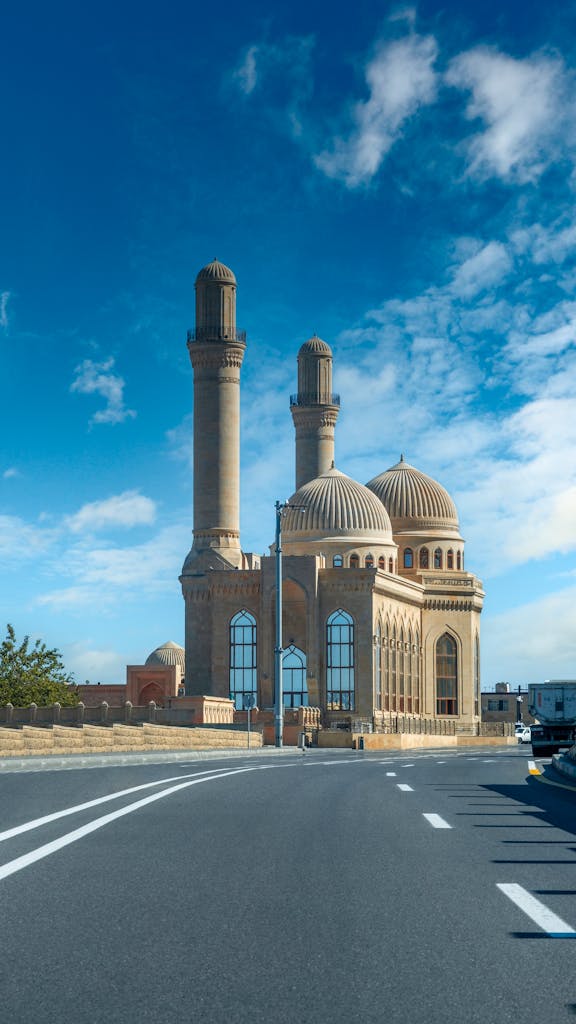 Voozon Bibi Heybat Mosque in Baku, Azerbaijan, with its iconic domes and minarets against a bright blue sky.