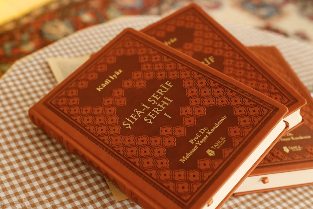 Dream11 Team Today Close-up of traditional books with ornate covers on a checkered tablecloth, creating a vintage ambiance.