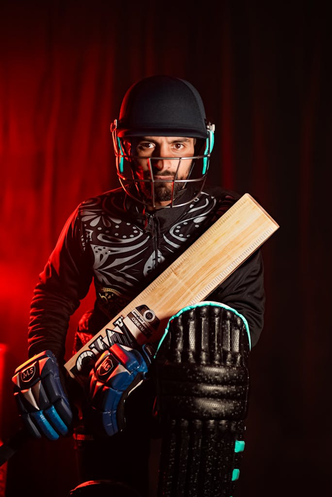 CSK New Captain Dynamic portrait of a cricketer in full gear, holding a bat ready for action.