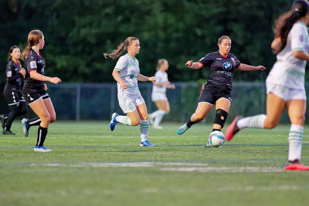 Full Match List Dynamic scene from a women's soccer match, capturing players in motion on the field.