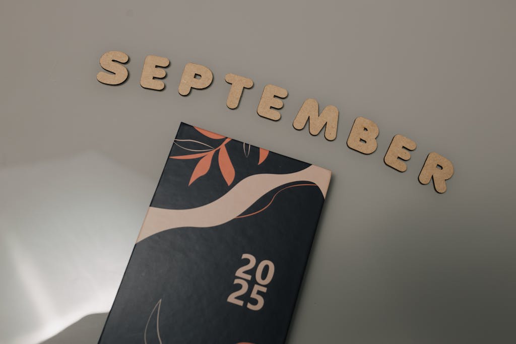 IPL 2026 Schedule Flat lay of a 2025 calendar with September in wooden letters and an autumn design on a neutral background.