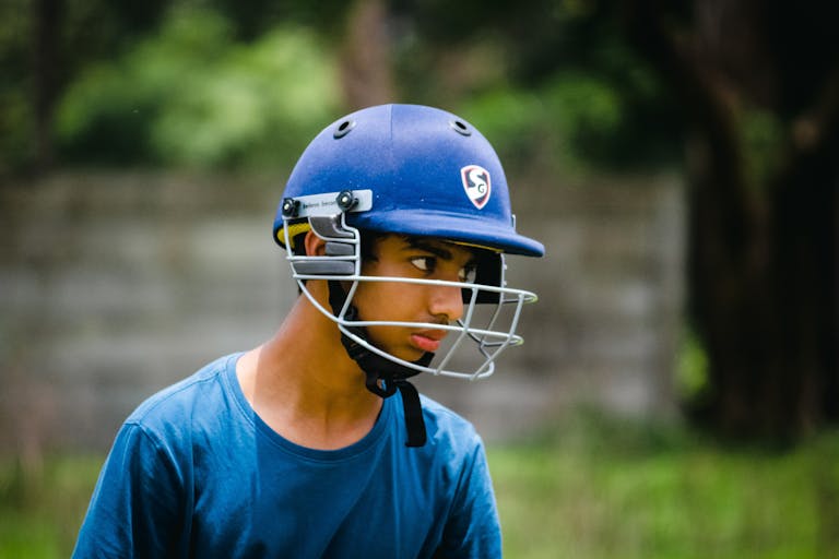 Orange Cap List Portrait of a young cricketer wearing a helmet outdoors in Pune, India.