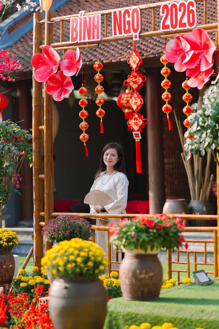 IPL 2026 Schedule Young woman in traditional setting celebrating the Vietnamese New Year with flowers and decorations.